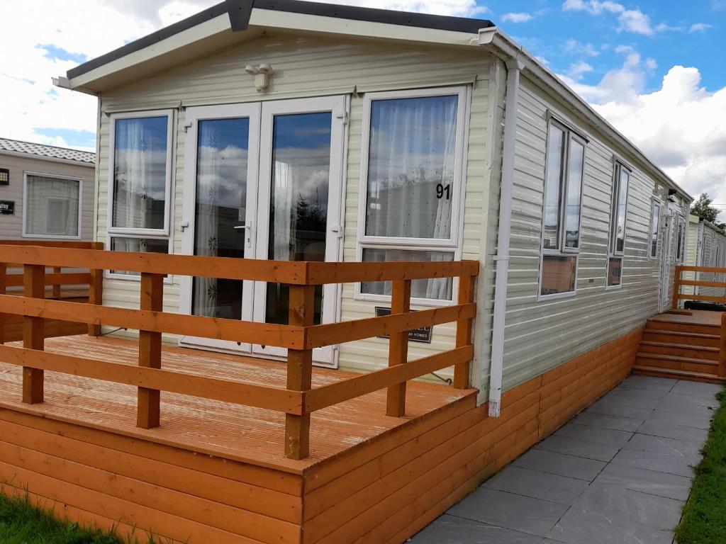 a mobile home with a large deck at Oak in Denny