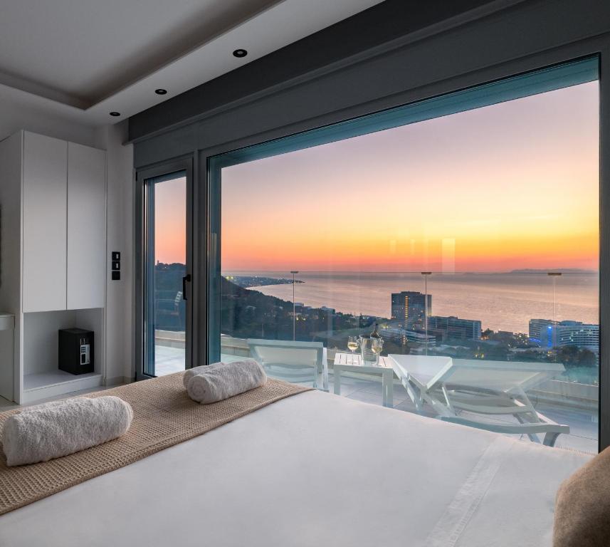 a bedroom with a bed and a large window at Rhodes SkyLine Suites in Ixia