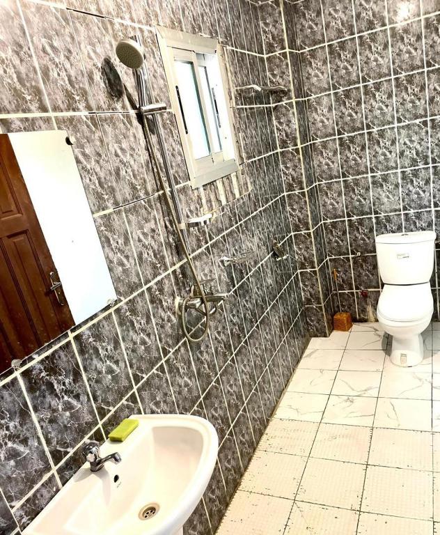 a bathroom with a sink and a toilet and a mirror at sidof Redence L&A in Yaoundé