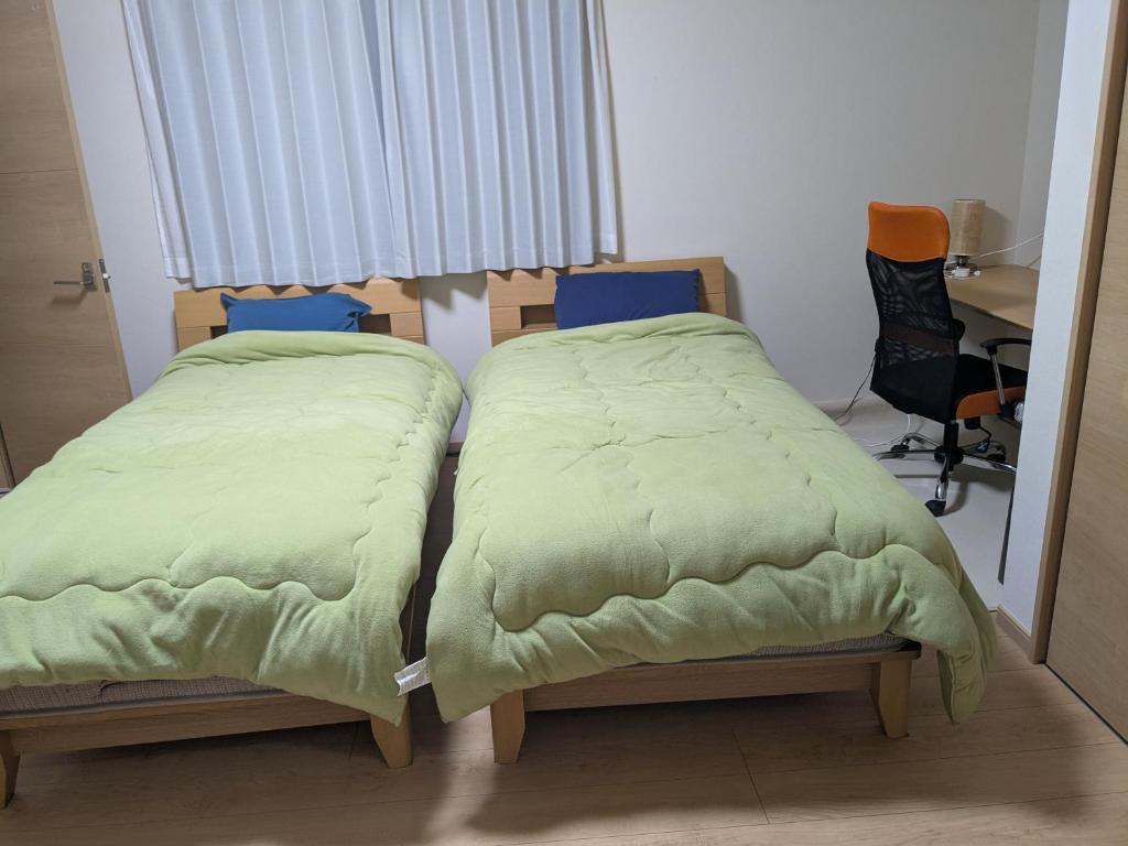 two beds sitting next to each other in a room at ル カフェ プランタニエ in Yokote