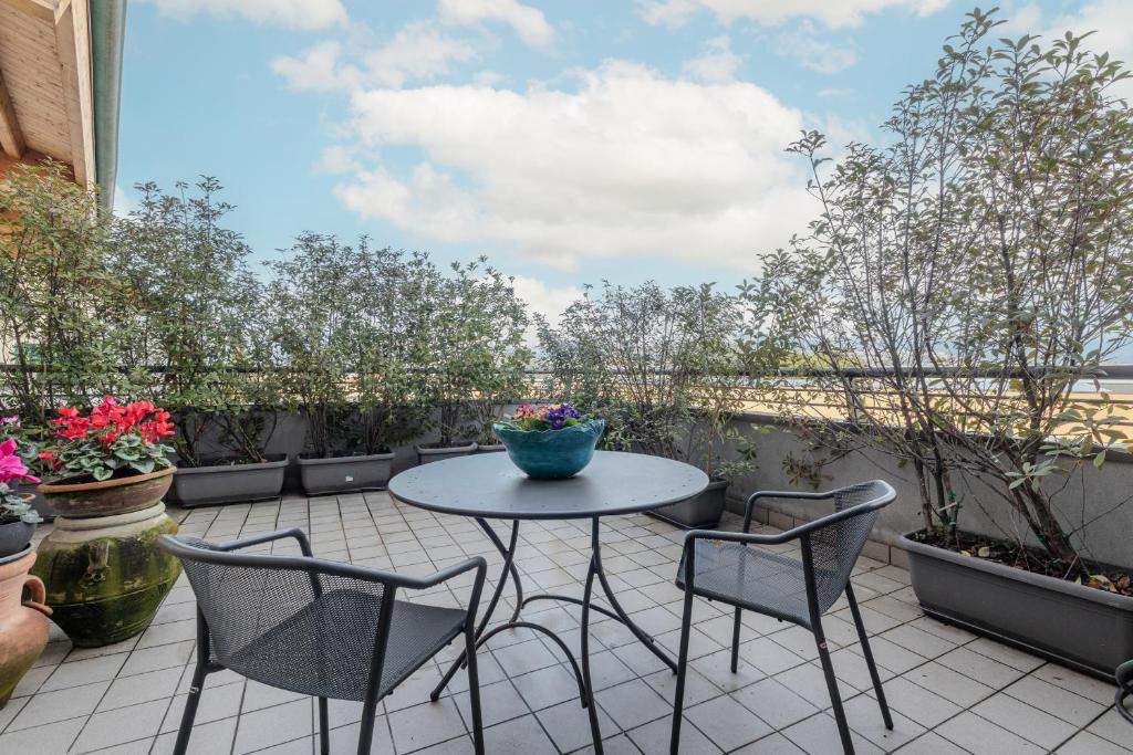 a patio with a table and chairs and plants at Charme a Bergamo in Bergamo