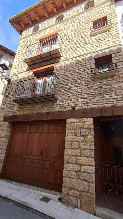 a brick building with two garage doors and two windows at Casa Mola in Forcall
