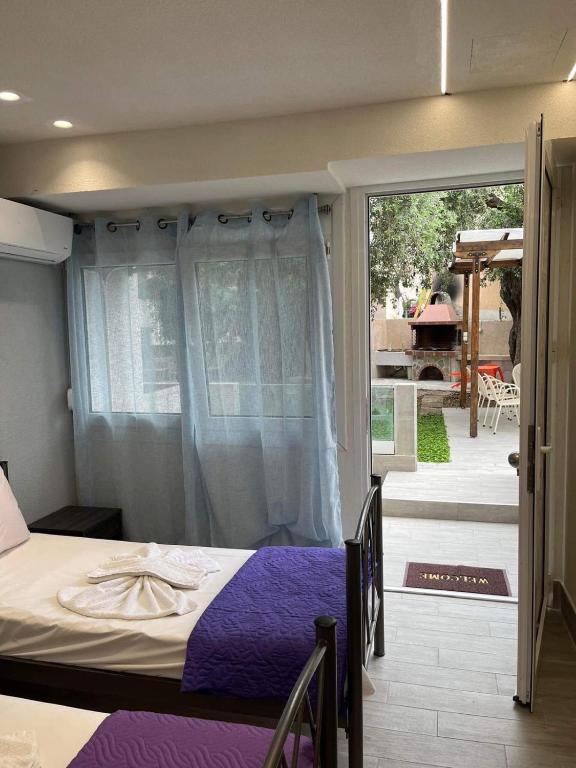 a bedroom with a bed and a sliding glass door at Kyano Studios-Sotiria studios in Limenaria