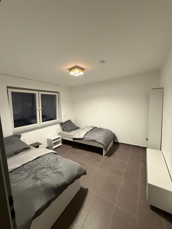 a bedroom with two beds and two windows at AM Apartment 8 in Gronau