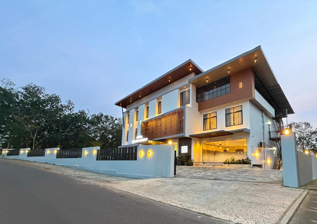 a large house with lights on the side of a street at Hotel Grand Residency in Mannārakkāt