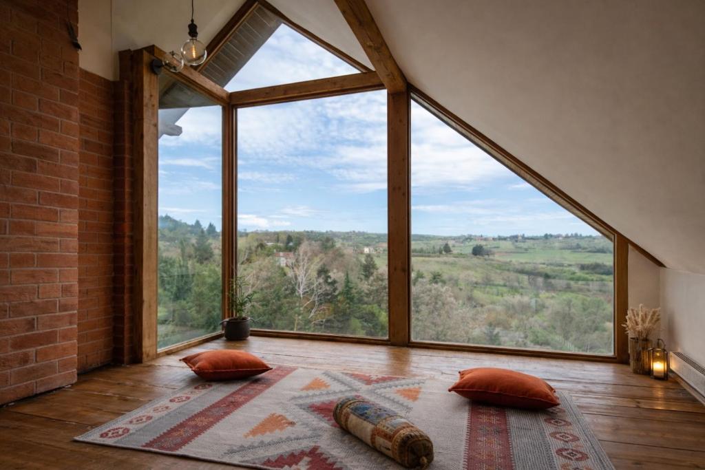 a large window in a room with a large bed and pillows at Matea Slow Living Home Private Retreat in Čortanovci