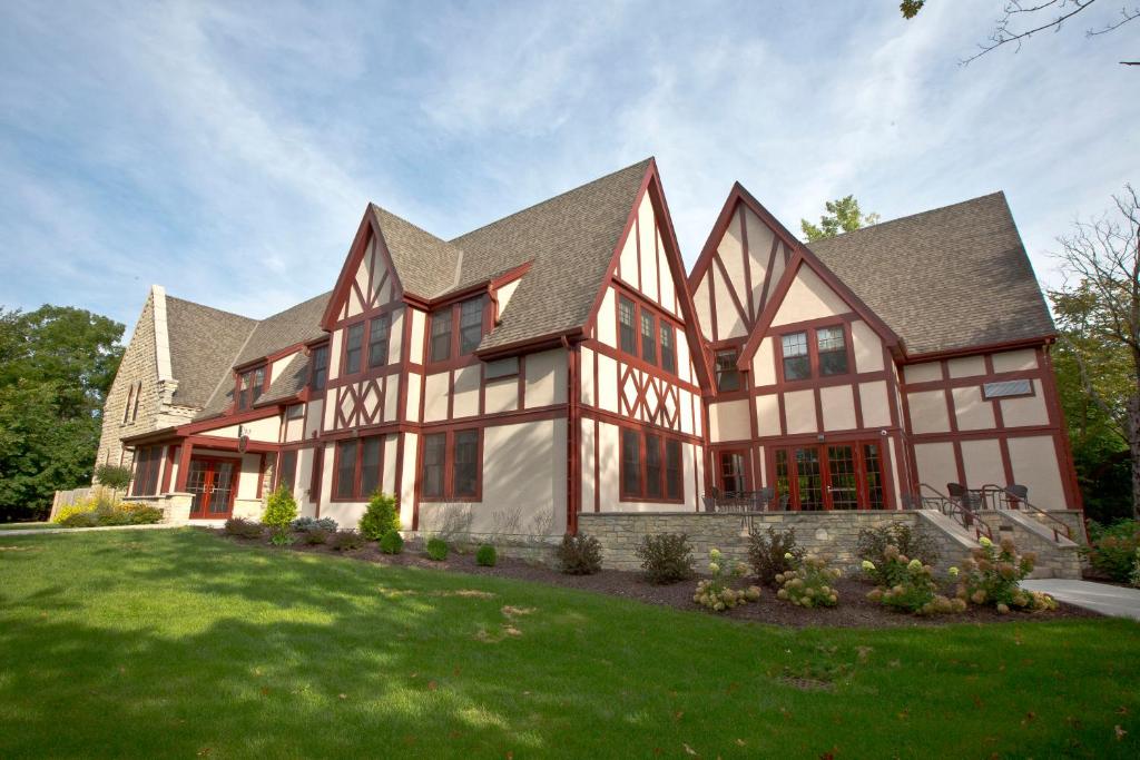 una casa grande con césped verde en The Inn at Shattuck - St. Mary's en Faribault