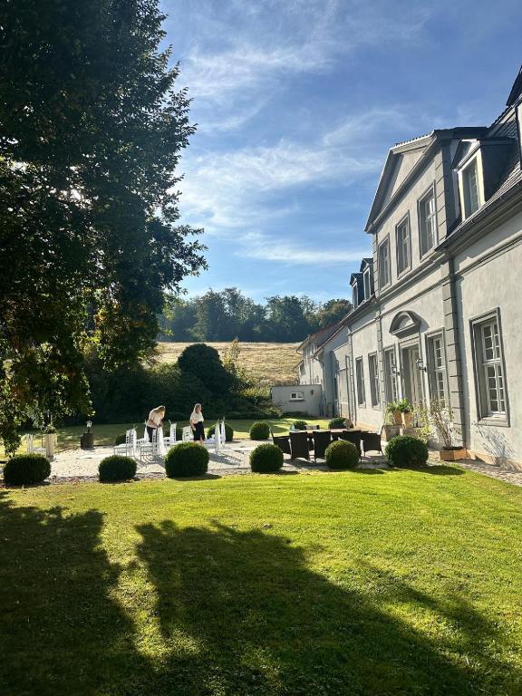 a house with a yard with chairs and a table at Jagdschloss Friedrichsthal in Waldeck