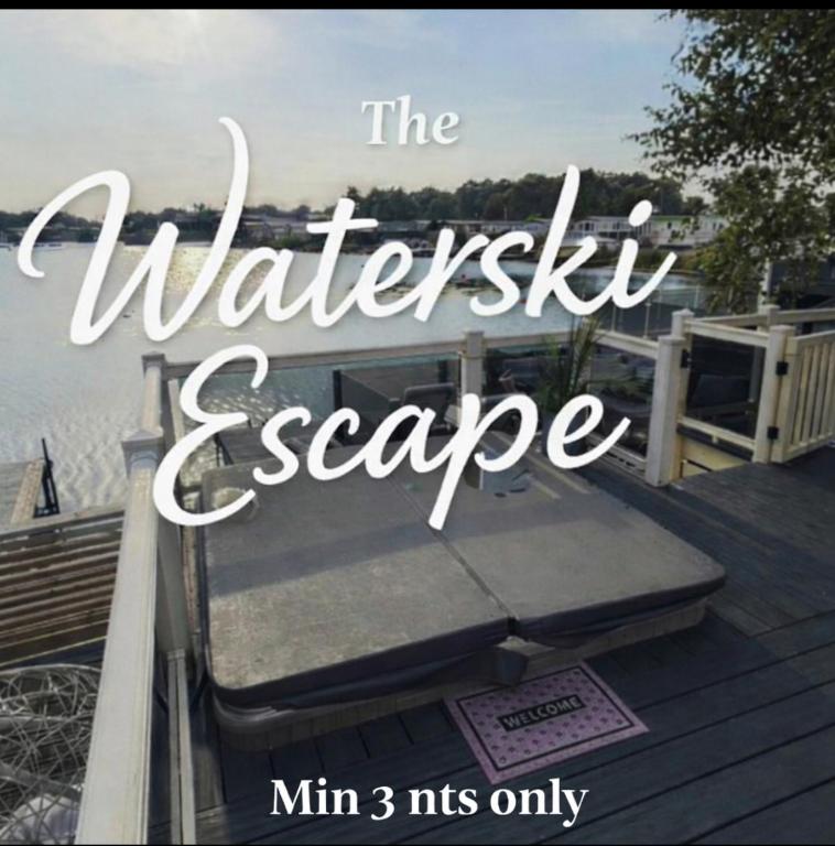 a sign that reads the waterisel escape with a view of the ocean at sunset luxury lakeside lodge with hot-tub,3 bedrooms, pet friendly in Tattershall