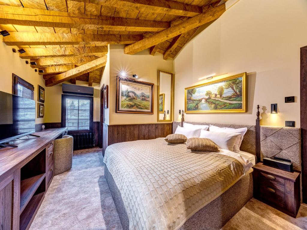 a bedroom with a large bed and a television at Pipers Lodge in Shiroka Laka