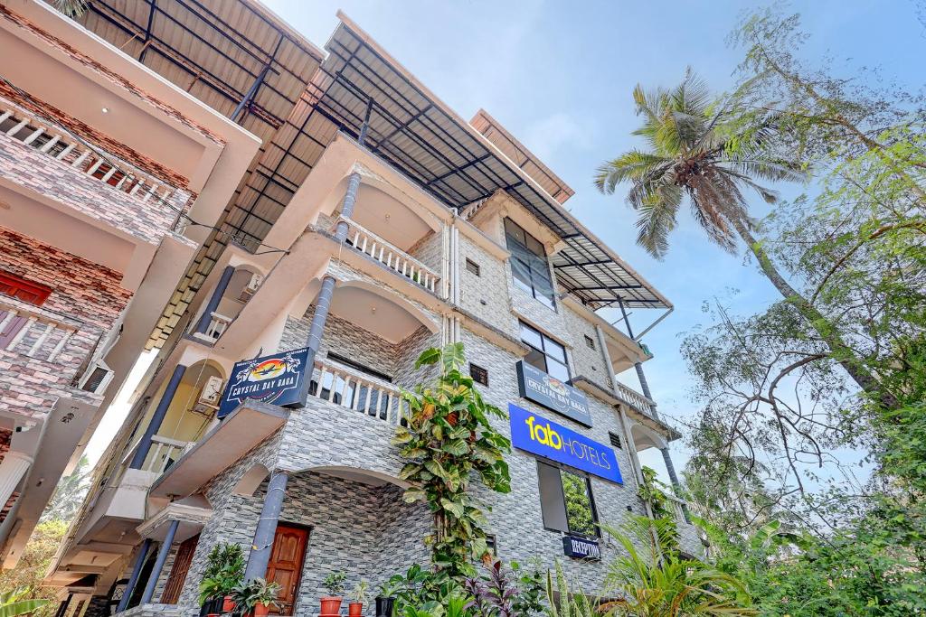 a building with a sign on the side of it at FabHotel Crystal Bay Baga in Baga
