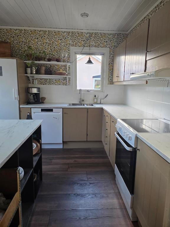 a kitchen with white appliances and a window at Stora Tegelhuset in Borlänge