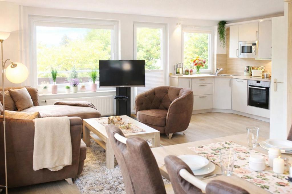a kitchen and living room with a table and chairs at Ole's BergSuite in Braunlage