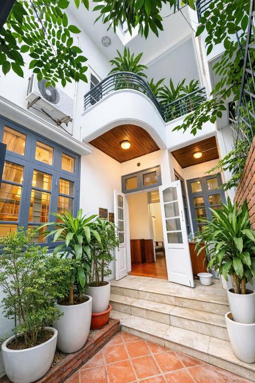 a house with plants in pots on the front door at Davidduc Villa 30 Tay Ho in Hanoi