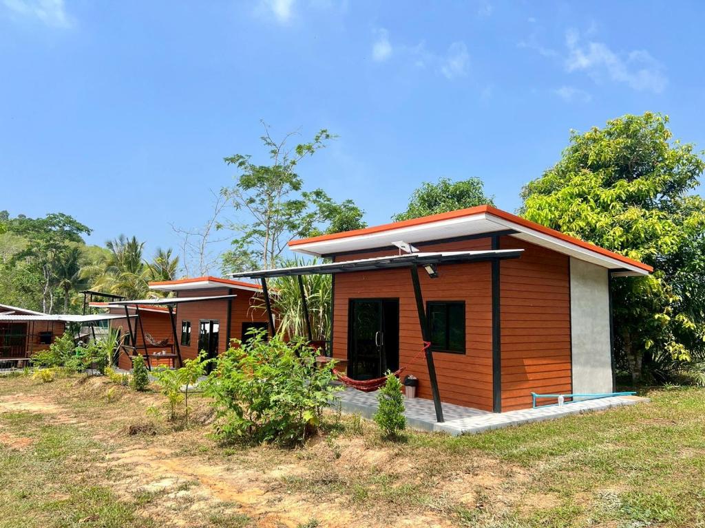 a small house in the middle of a field at Lanta Baan Suan Yoo Dee in Ban Nong Chaeng