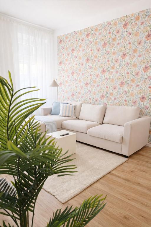 a living room with a white couch and a plant at Suites in Brunn am Gebirge in Brunn am Gebirge