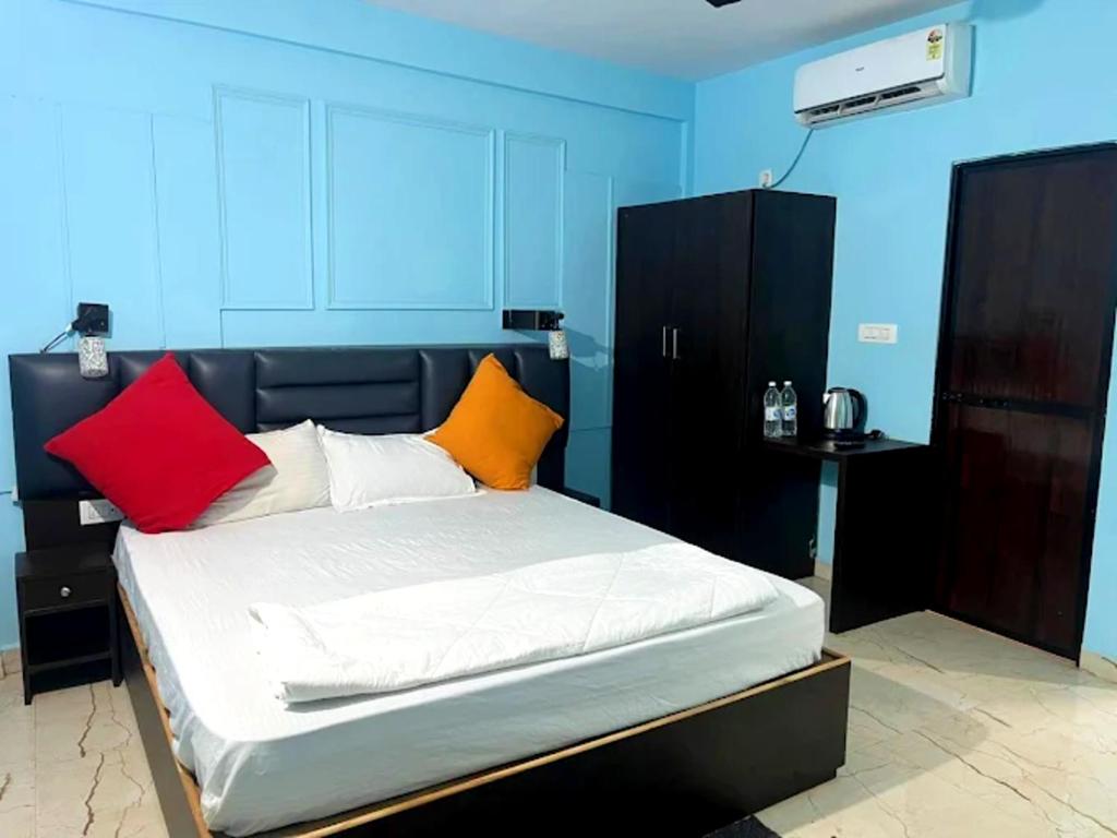 ein Bett mit bunten Kissen in einem Zimmer in der Unterkunft Hotel The B House Goa in Agonda