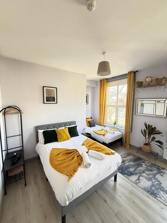 a bedroom with a large white bed with yellow sheets at The Wolfs Tavern in London