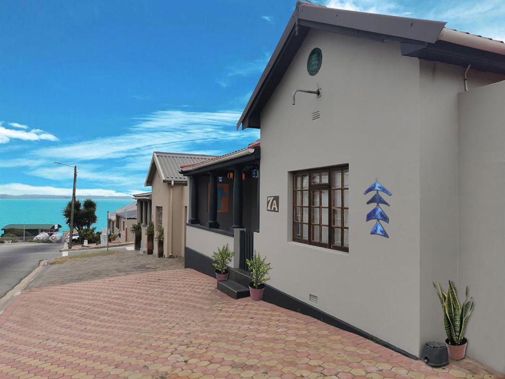 a white building with a red brick driveway at Harbour House Mossel Bay - near sea & activities in Mossel Bay