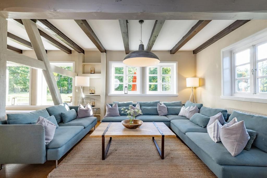 a living room with blue couches and a table at Haus im Wald in Gartow