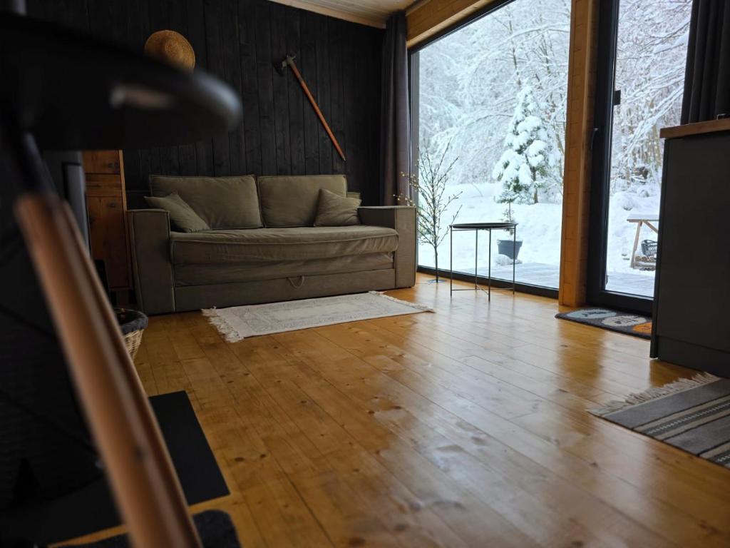 a living room with a couch and a wooden floor at Модрина Космач ko kosmach in Kozmacz
