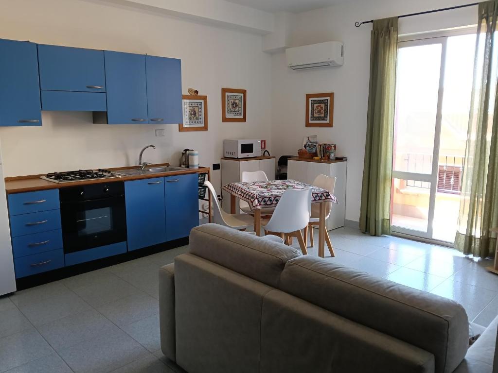 a living room with a couch and a kitchen with a table at Salina in Trappeto