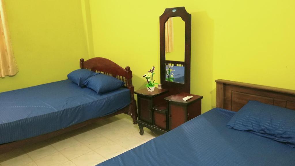 a bedroom with two beds and a mirror and a tv at Pasindu Garden in Vavuniya