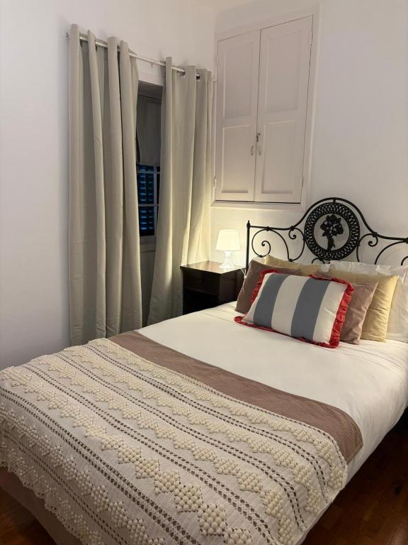 a bedroom with a bed with white walls and curtains at Casa da Torre in Porto Moniz