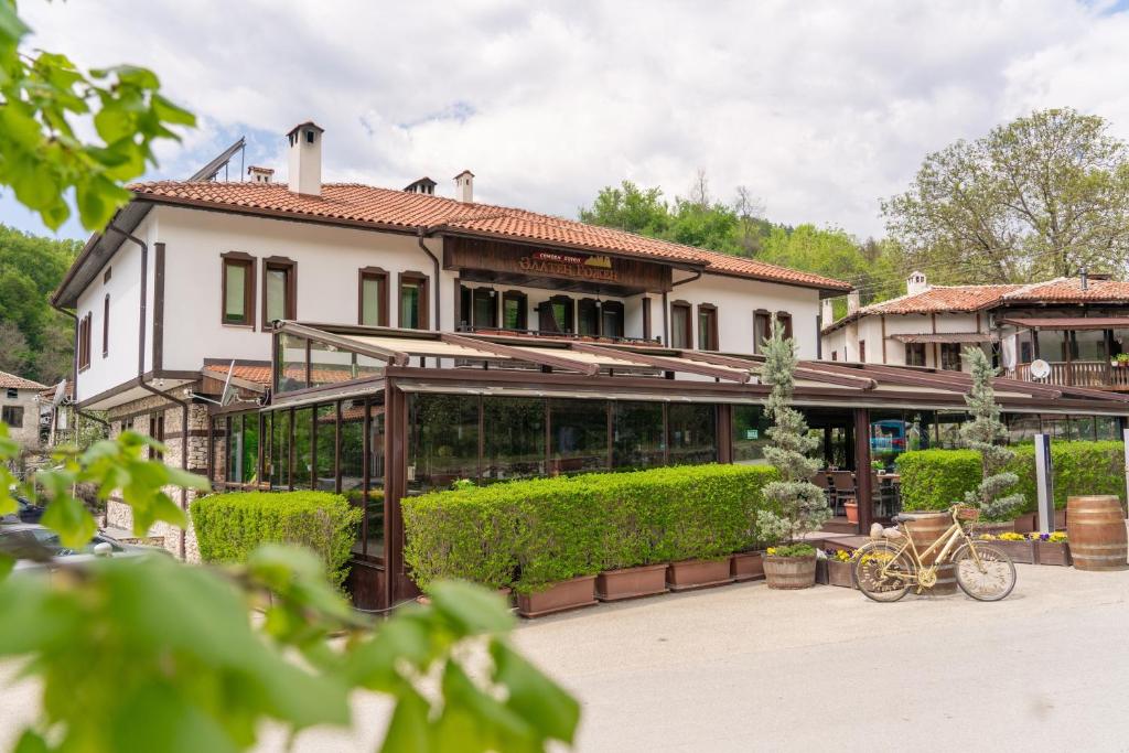 a house with a bike parked in front of it at Zlaten Rozhen Family Hotel- Monument of Cultural Significance in Rozhen