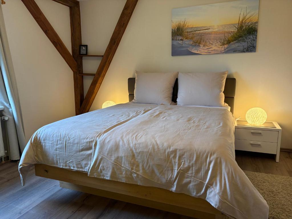 a bedroom with a large bed with white sheets at Apartments Schnepel in Sankt Michaelisdonn