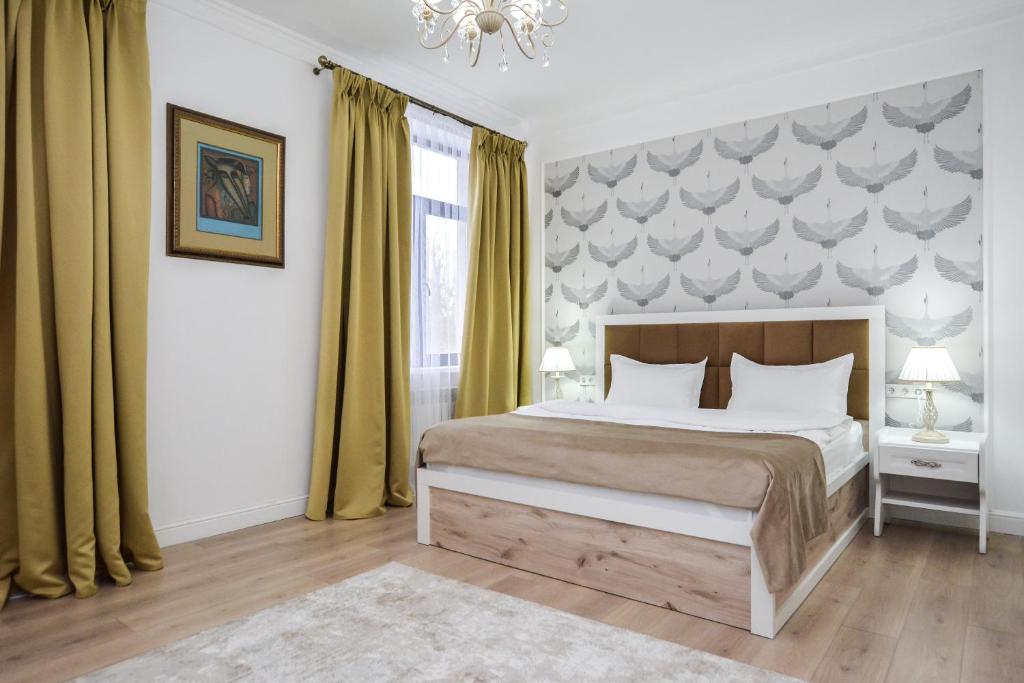 a bedroom with a large bed and a chandelier at Hotel Astoria, в самом центре города in Astana