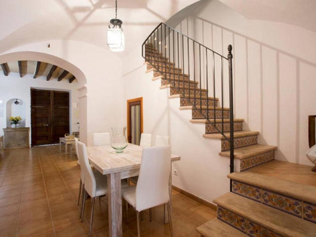 a dining room with a table and a staircase at Ca'n Climent in Llucmajor