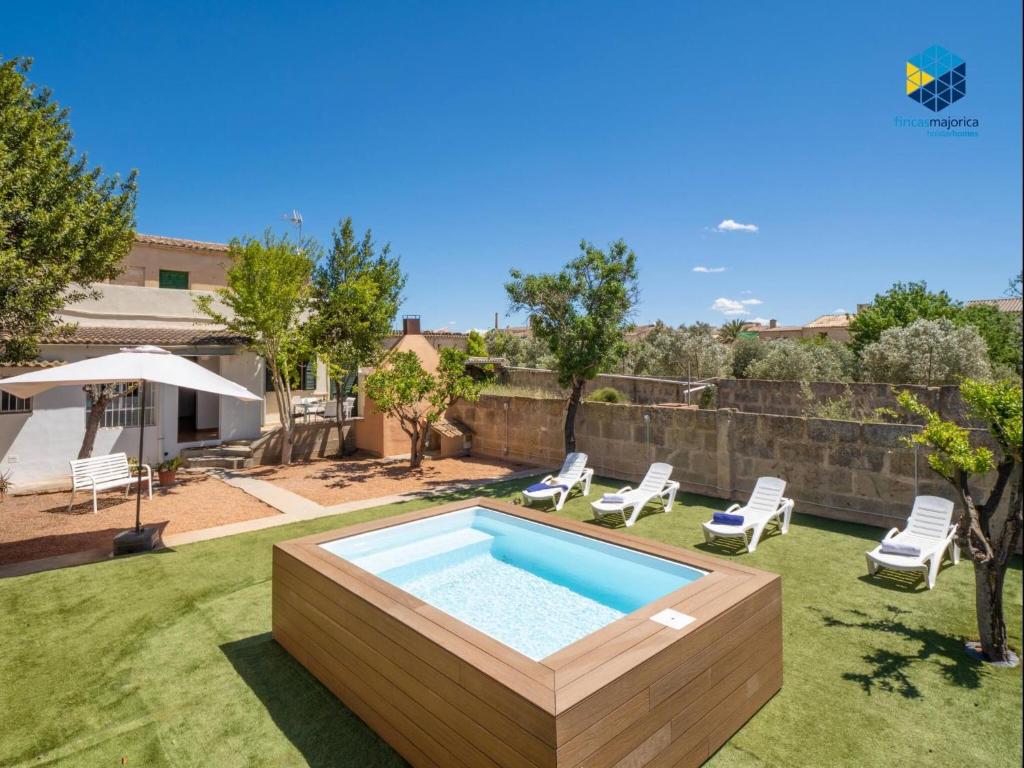 a backyard with a swimming pool and chairs at Ca sa comare in Llucmajor