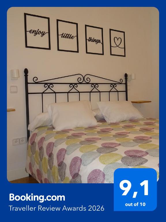 a bedroom with a bed with a comforter and pictures on the wall at VUT Casa de la Catedral Baja in Sigüenza