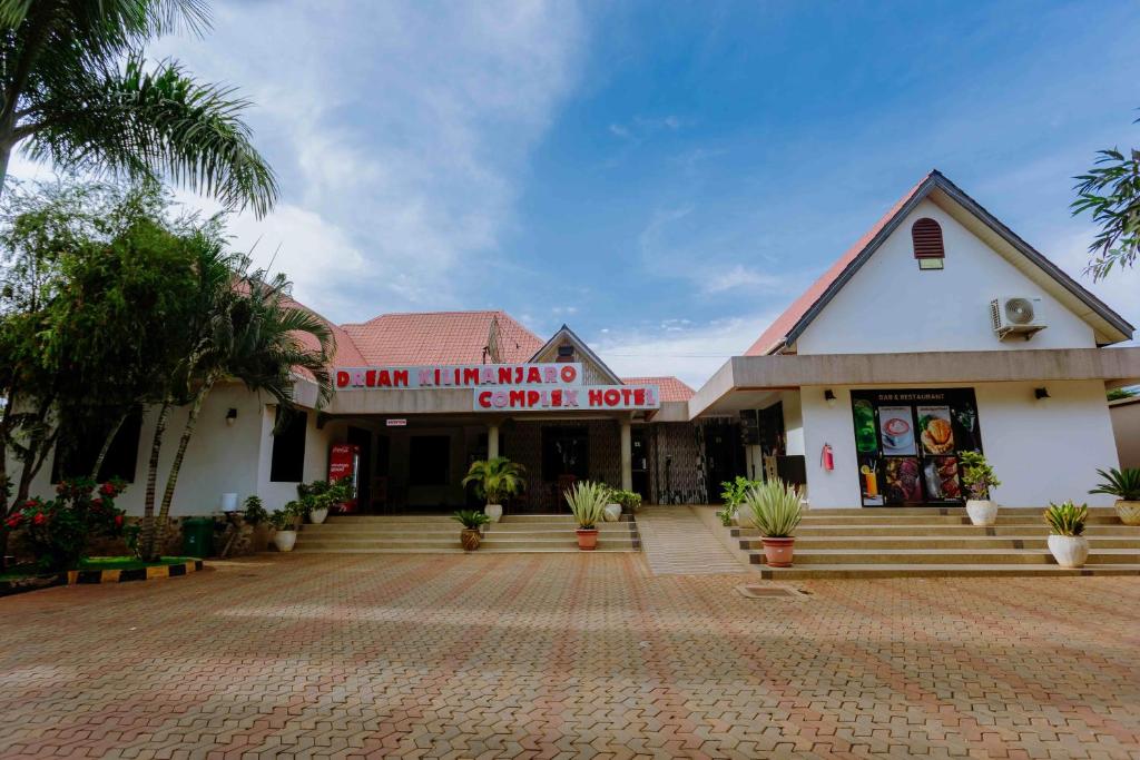 a building with a red sign on the front of it at Dream Kilimanjaro Complex Hotel in Msaranga