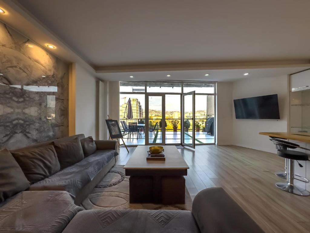 a living room with a couch and a table at Amelia Terrace Escape in Tbilisi City