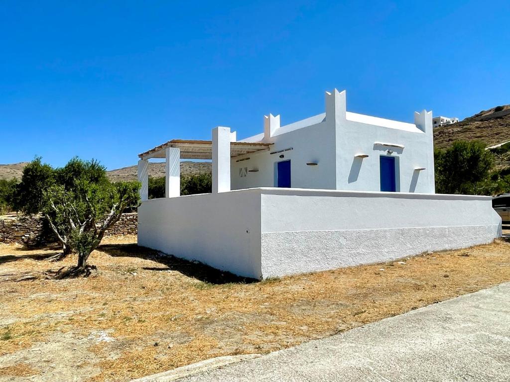 a white house in the middle of a field at Iosub Houses & Studios - Beach House in Koumbara in Tzamaria