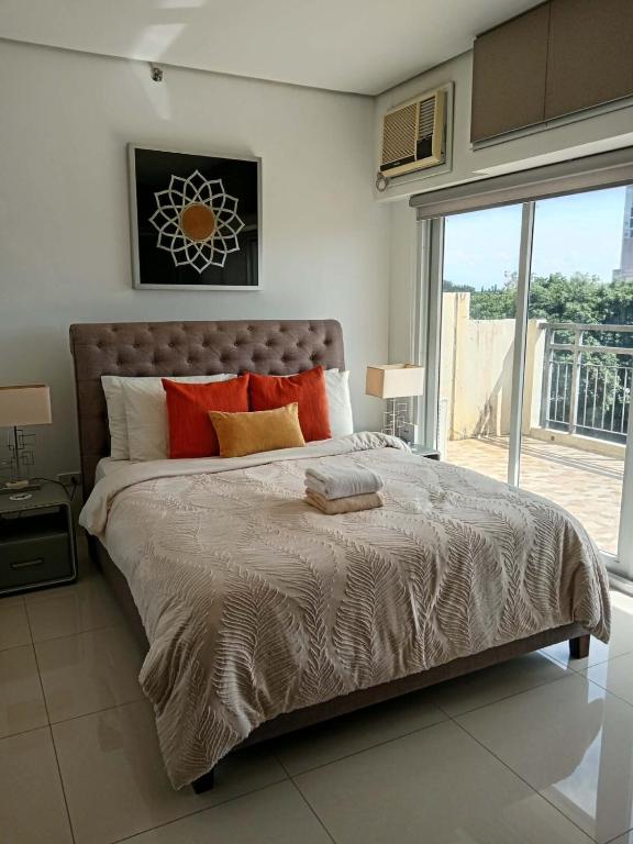 a bedroom with a large bed and a large window at Sweet Escape 22 at O Residences in Bacolod