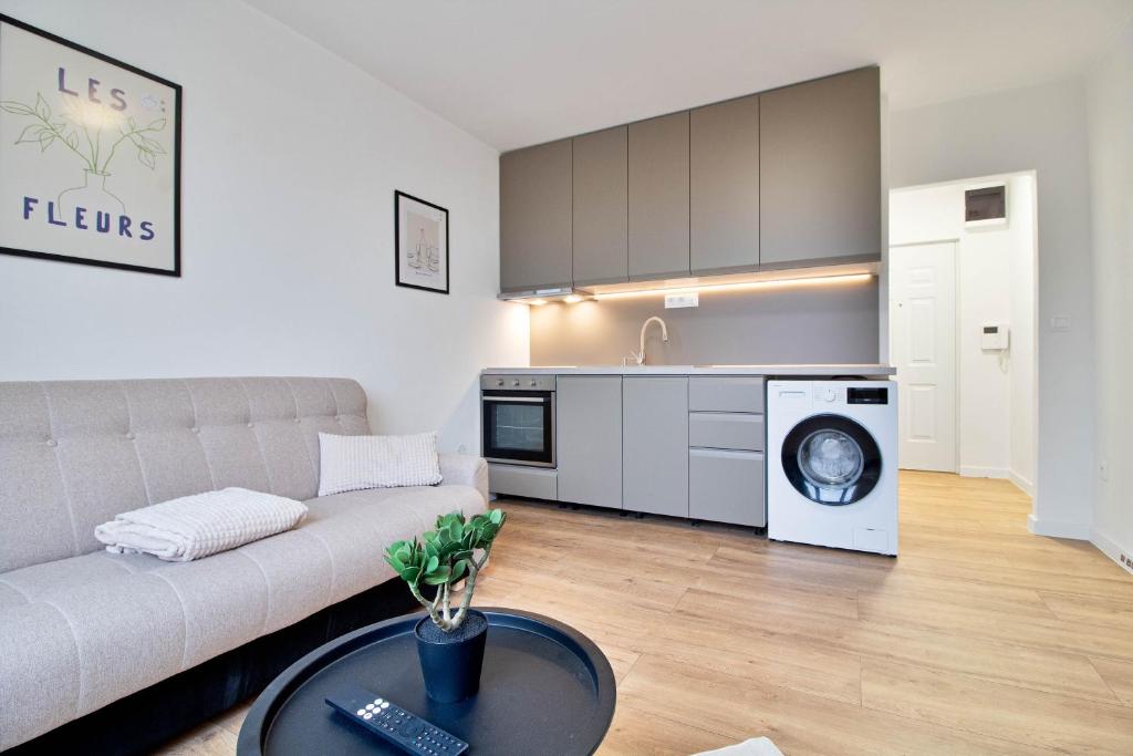 a living room with a couch and a washing machine at Moskovska with Public Parking in Banská Bystrica