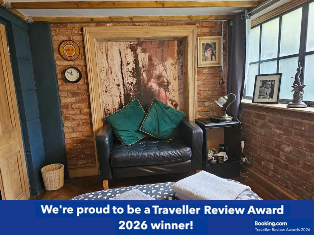 a living room with a leather couch and a clock at City Centre Stylish Hideaway in Exeter