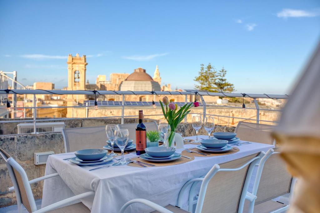 a table with glasses and a bottle of wine on a balcony at Stunning 3BR breathtaking views outdoor dining in Rabat
