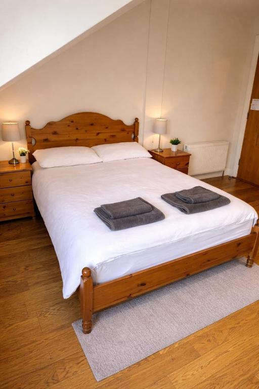 a bedroom with a large wooden bed with white sheets at Slieve League Lodge in Carrick