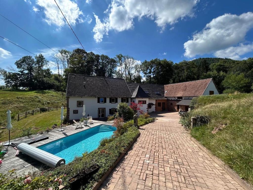 a house with a swimming pool in front of it at Casa Mypi in Reinhardsmunster