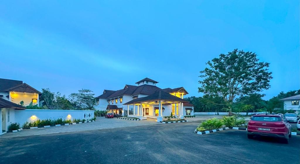 a house with a car parked in the driveway at Maramon Hotel & Resort in Pathanāmthitta