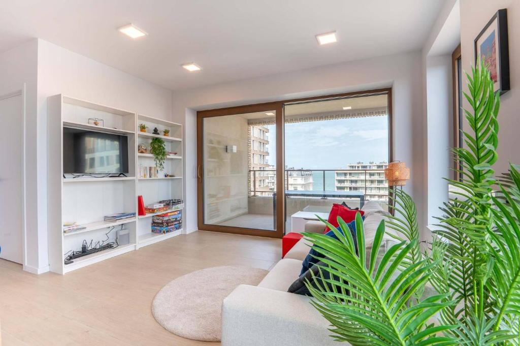 a living room with a couch and a tv at Perfectly situated condo with amazing views in Ostend