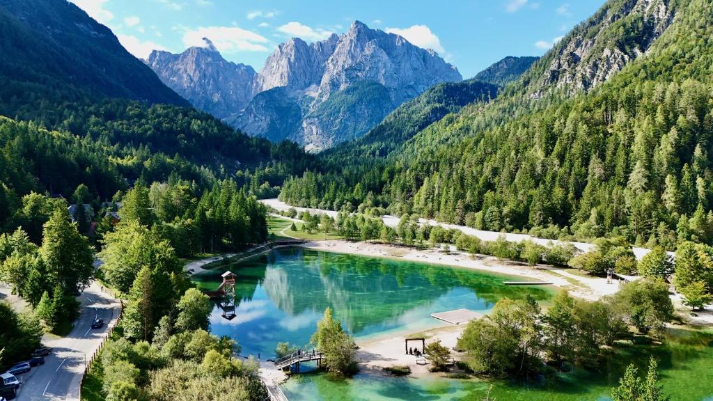 an aerial view of a lake in a valley with mountains at JASNA NATUR Resort by the lake in Kranjska Gora