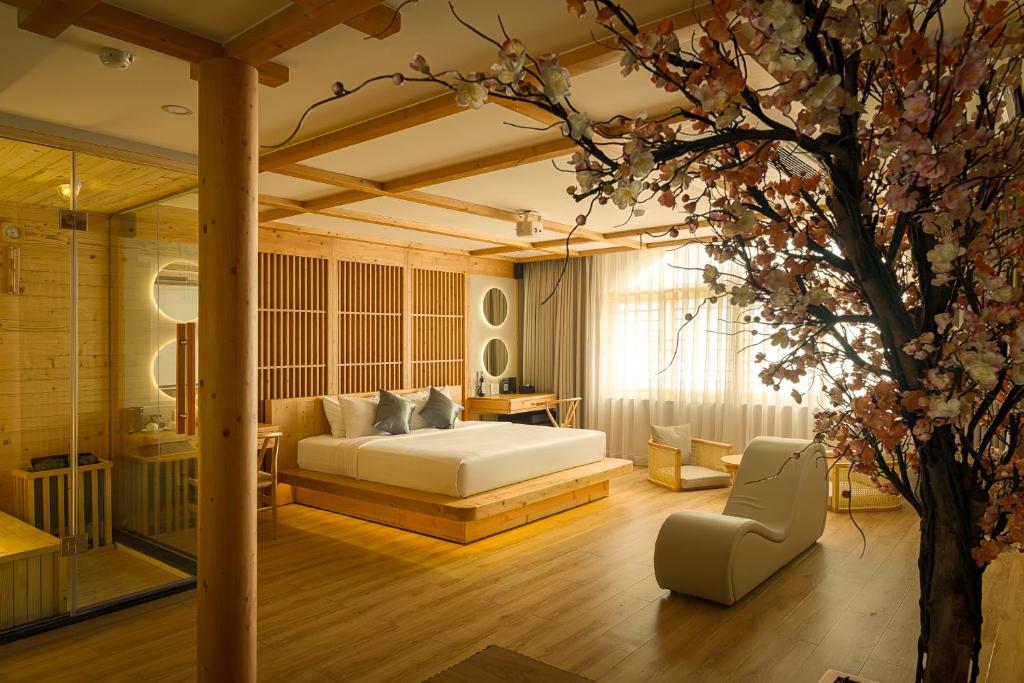 a bedroom with a bed and a tree at Cupid Hotel 3 in Ho Chi Minh City