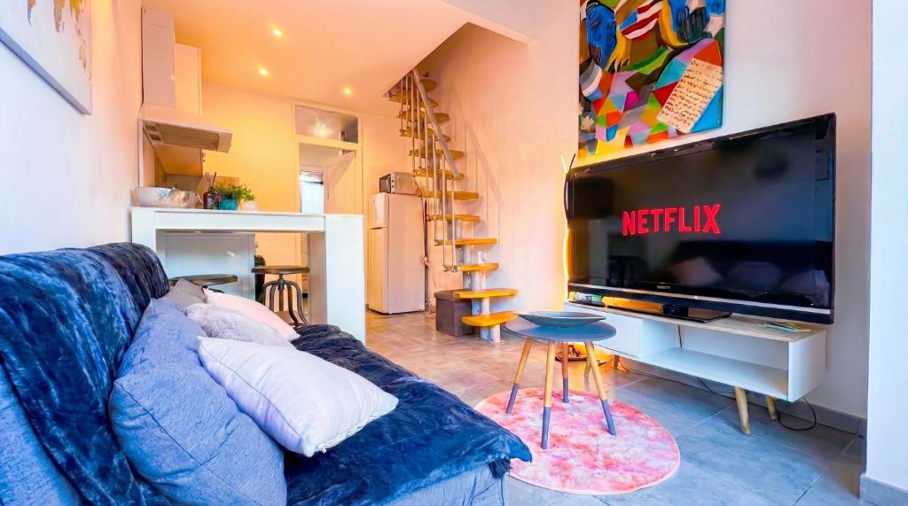 a living room with a blue couch and a tv at Cozy & elegant, proche de Martigues in Saint-Mitre-les-Remparts