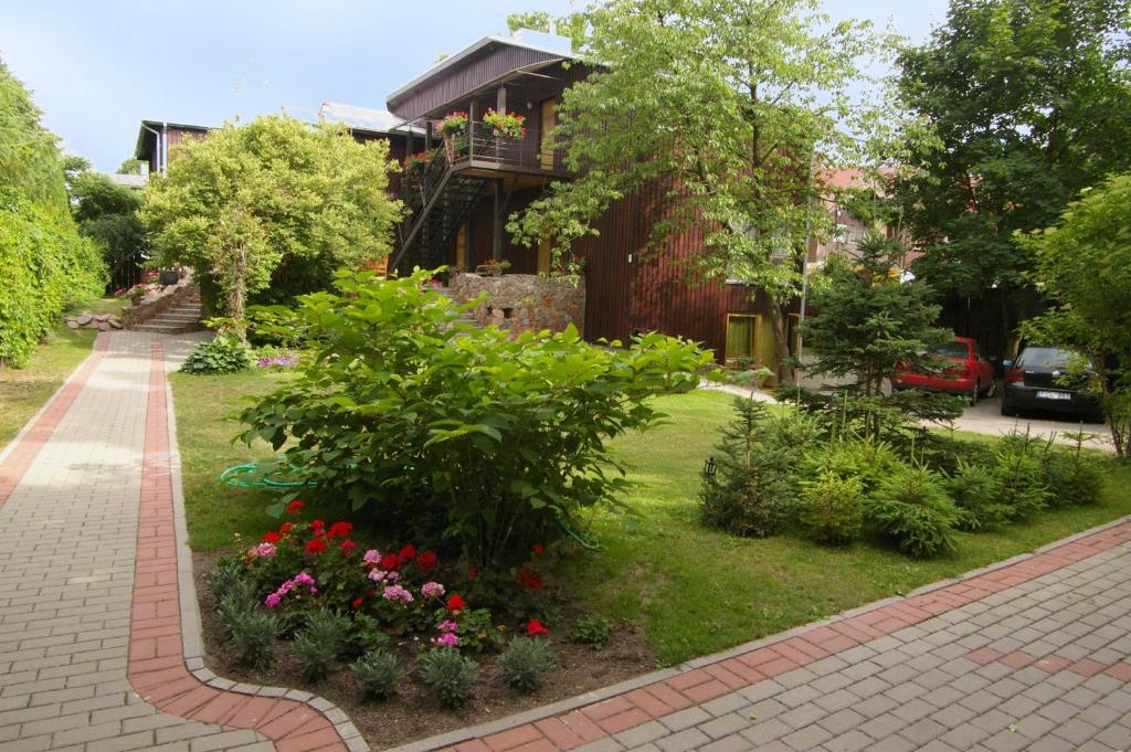 a garden in front of a house with flowers at Arciau Juros in Palanga