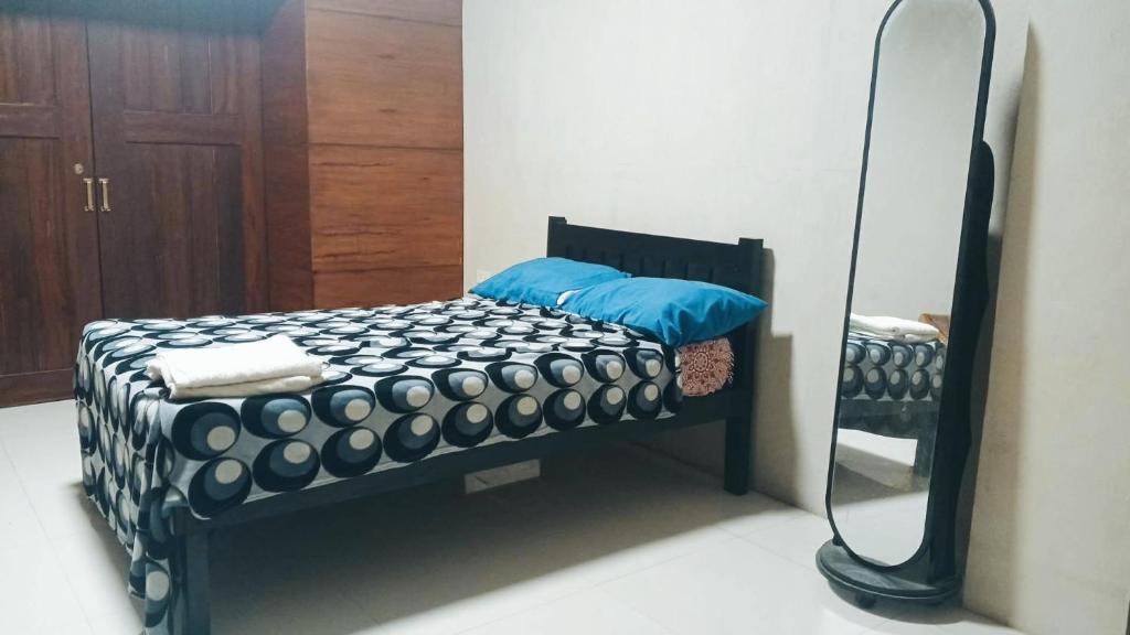 a bed in a room with a mirror at RnR Suites in Dagupan